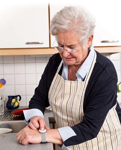 Frau benutzt Notrufknopf am Arm